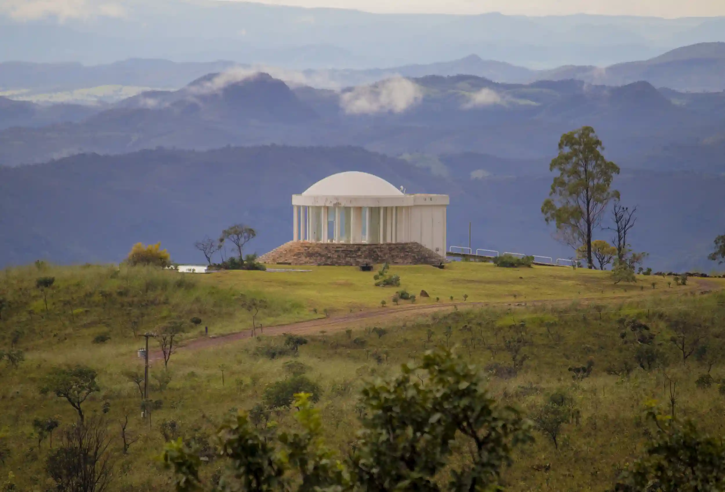 Templo de meditação no alto de uma colina, com montanhas ao fundo